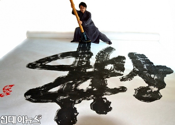 한한국 세계평화작가가 12M 초대형 '평화의佛'을 쓰고 있는 모습(사진=세계평화사랑연맹)